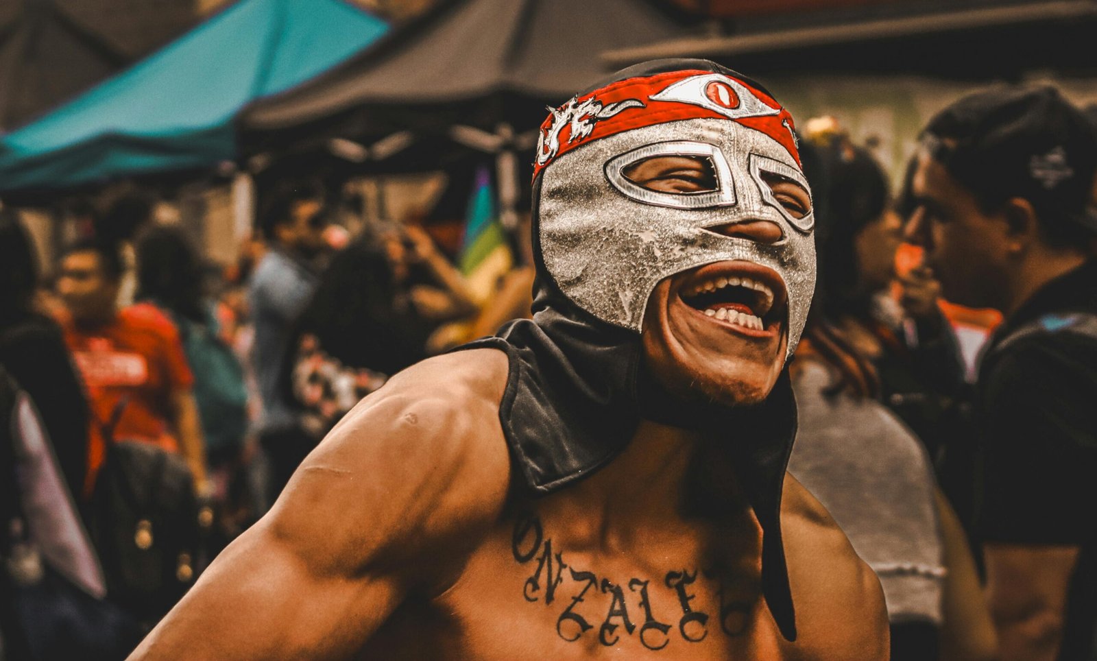 Dynamic photo of a masked wrestler enjoying a lively outdoor street festival.